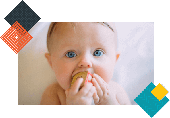 Baby holding onto a letter block.