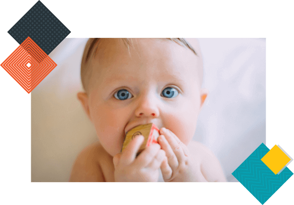 Baby holding onto a letter block. 